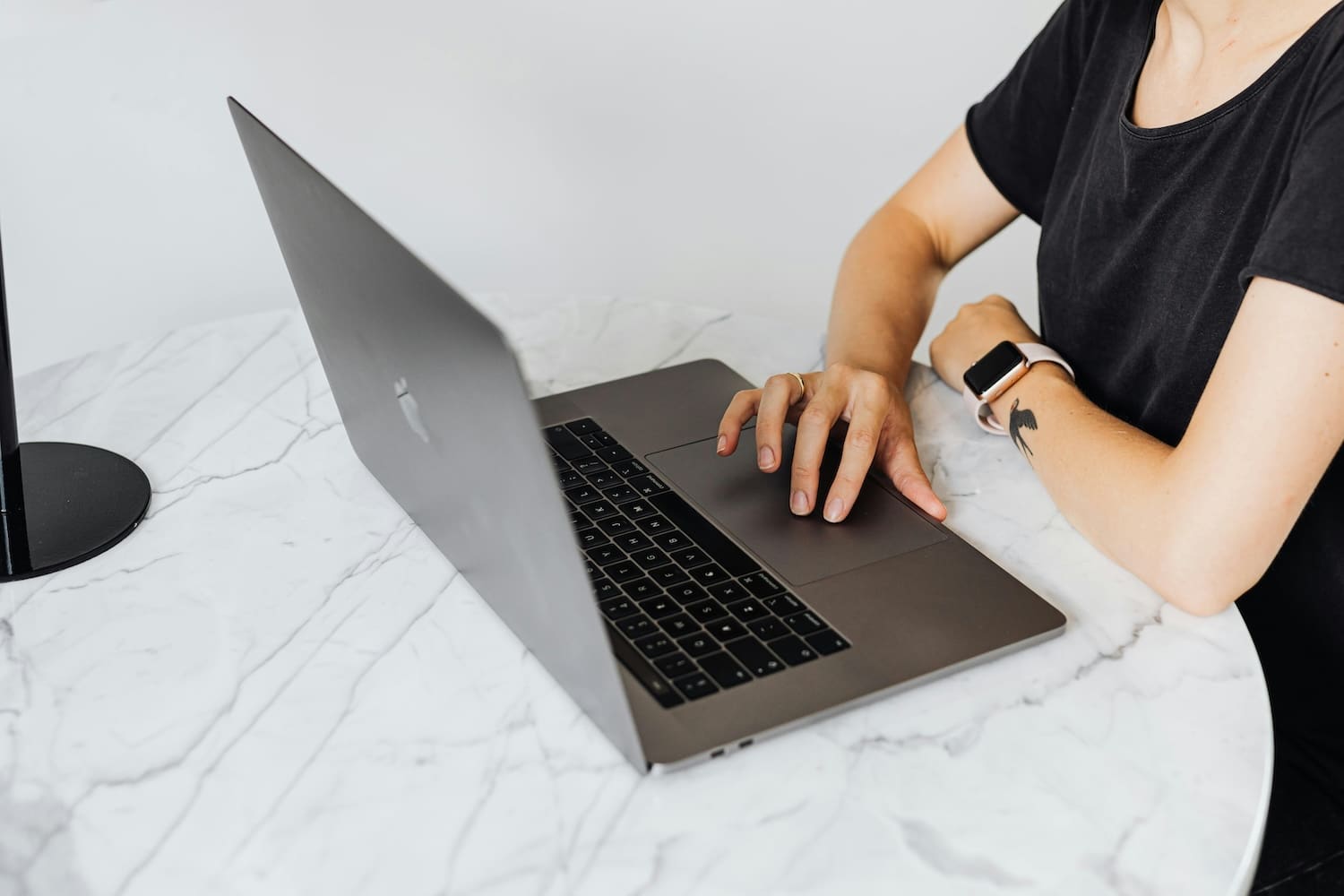 A woman looking at her computer, learning how to get more followers on TikTok.